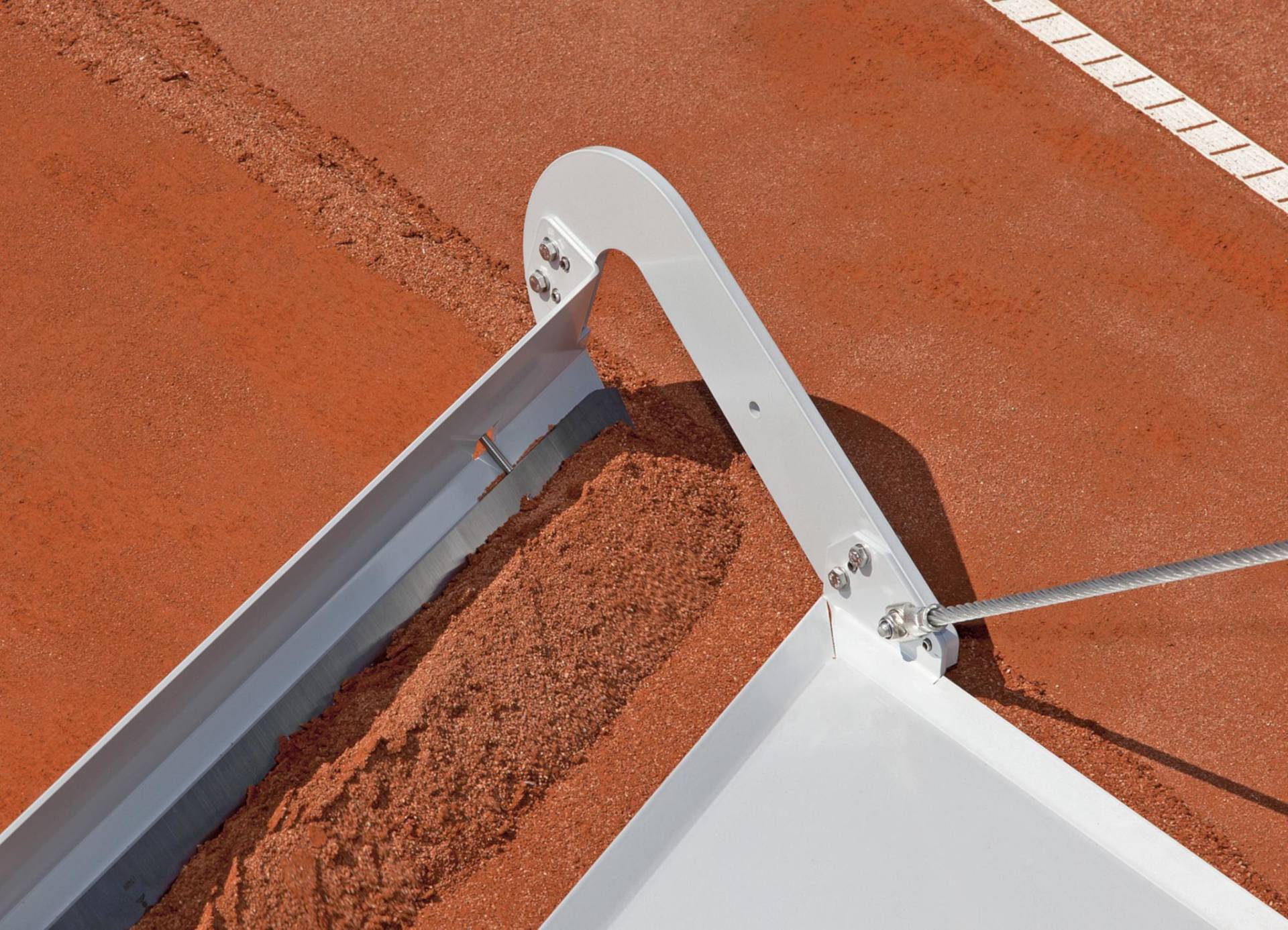 <i class='fas fa-angle-double-right'></i> The sand cutter TM2 in use. The steel plate slides over the used sand. The main blade, fixed 2mm lower, cuts or scrapes off exactly the desired layer of used sand. The carefully angled TM2 pushes the used sand outwards.